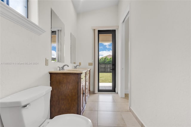 bathroom with vanity, lofted ceiling, toilet, and tile patterned floors