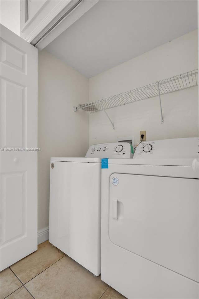 laundry room featuring light tile patterned flooring and washer and clothes dryer