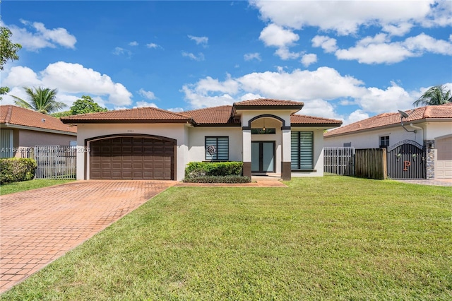 mediterranean / spanish home featuring a front lawn and a garage