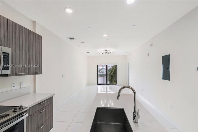 kitchen featuring electric panel, sink, light tile patterned floors, and electric stove