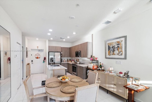 kitchen featuring sink, light tile patterned flooring, and appliances with stainless steel finishes