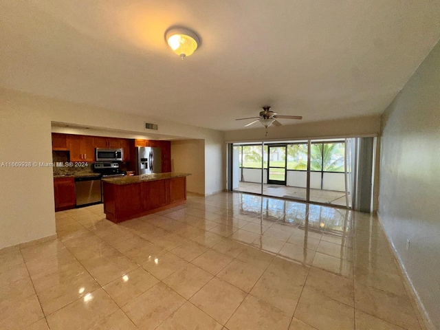 kitchen with ceiling fan, decorative backsplash, light tile patterned floors, and stainless steel appliances