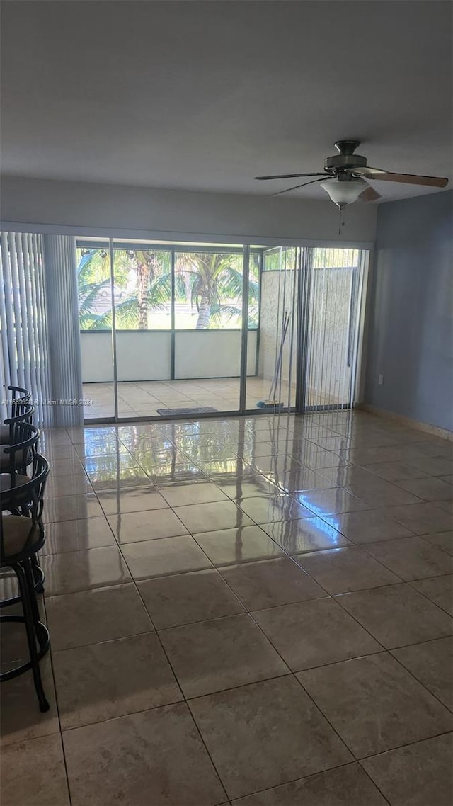 empty room featuring tile patterned floors and ceiling fan