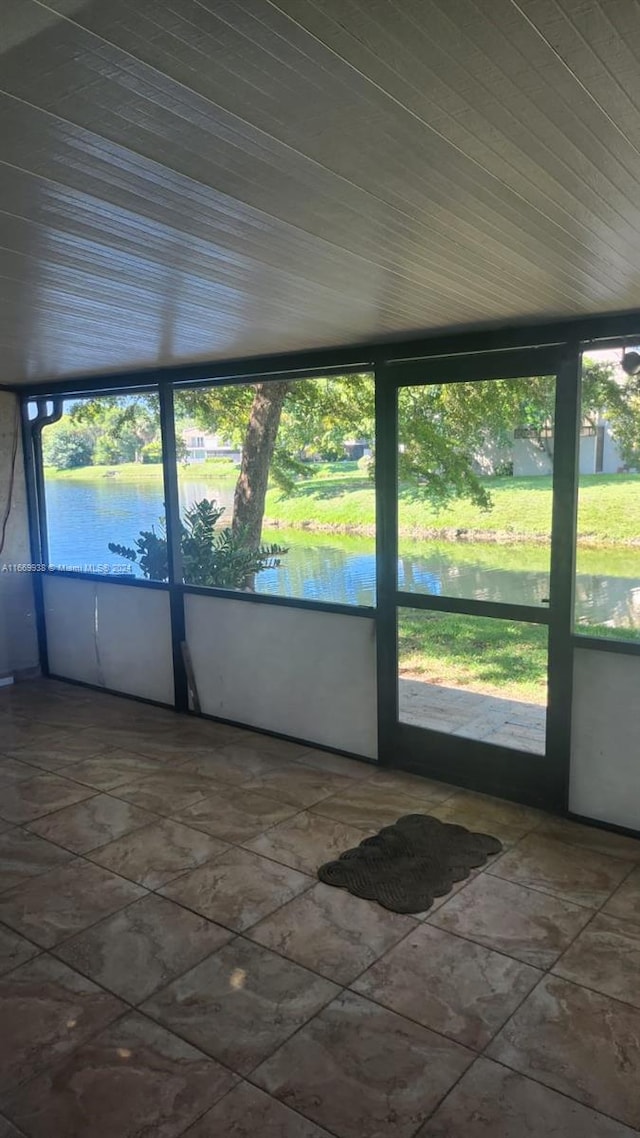 unfurnished sunroom with a water view