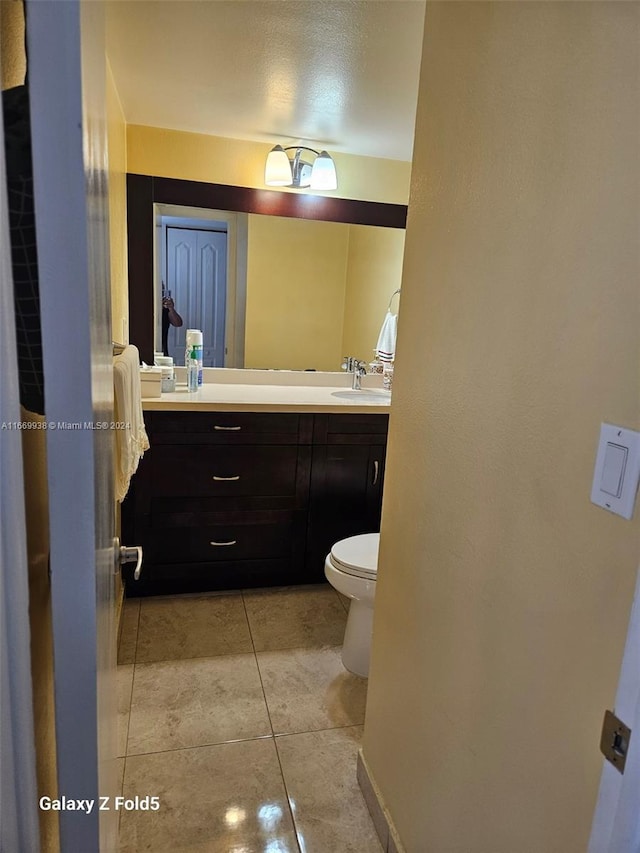 bathroom featuring tile patterned floors, vanity, and toilet