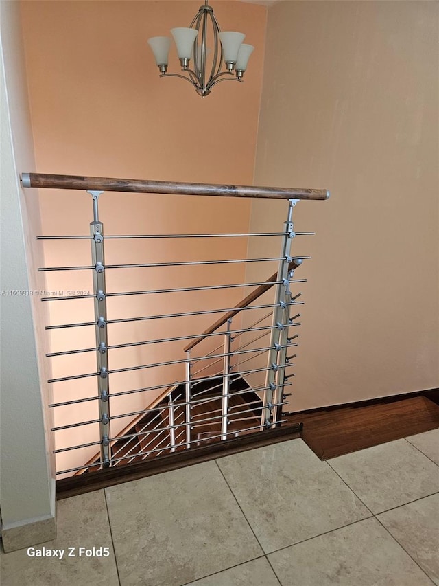 stairs with a chandelier and tile patterned flooring