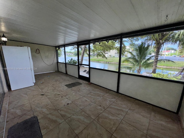 unfurnished sunroom featuring a water view and a healthy amount of sunlight