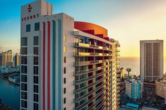 outdoor building at dusk featuring a water view and central AC unit