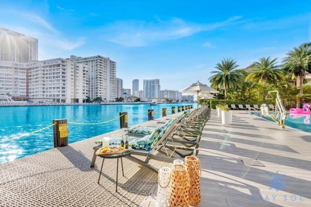 view of swimming pool featuring a view of city and a water view