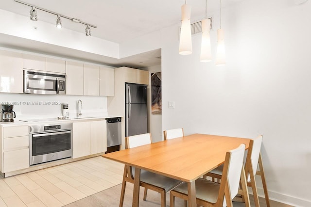 kitchen featuring light wood finished floors, visible vents, light countertops, appliances with stainless steel finishes, and a sink