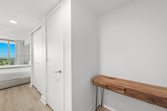 hallway featuring baseboards and light wood-style floors