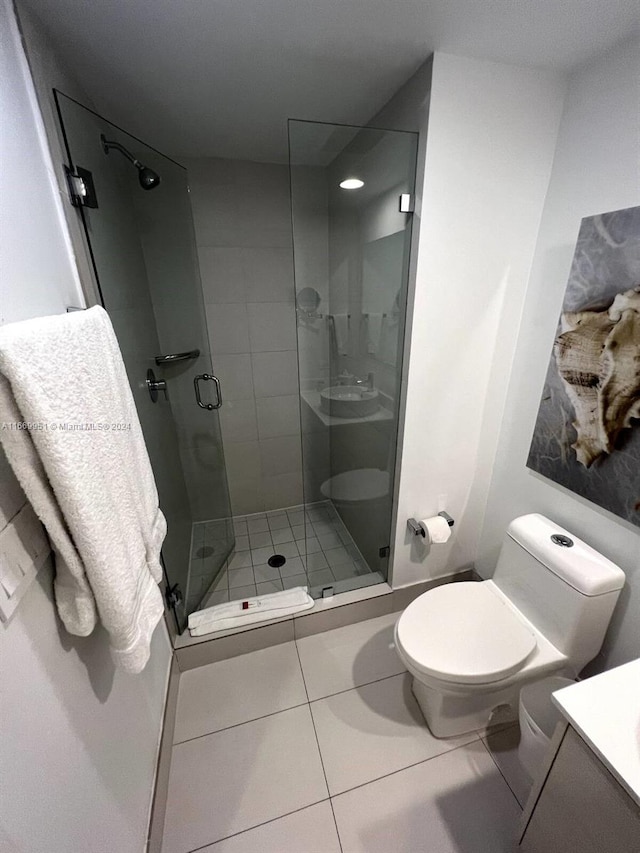 bathroom with walk in shower, vanity, toilet, and tile patterned floors