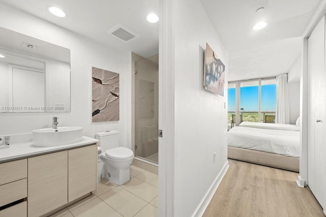 full bath with vanity, visible vents, a shower stall, ensuite bathroom, and toilet