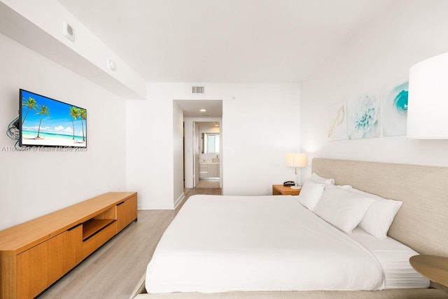 bedroom featuring visible vents, baseboards, and light wood-style floors