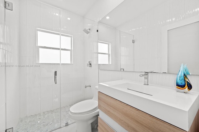 bathroom featuring an enclosed shower, vanity, and toilet