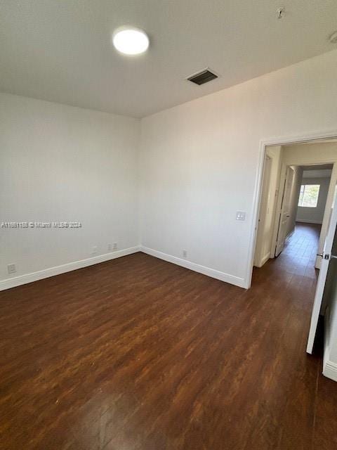 unfurnished room featuring dark wood-type flooring