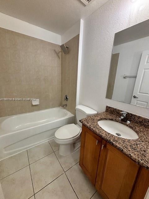 full bathroom with tiled shower / bath combo, vanity, toilet, and tile patterned floors