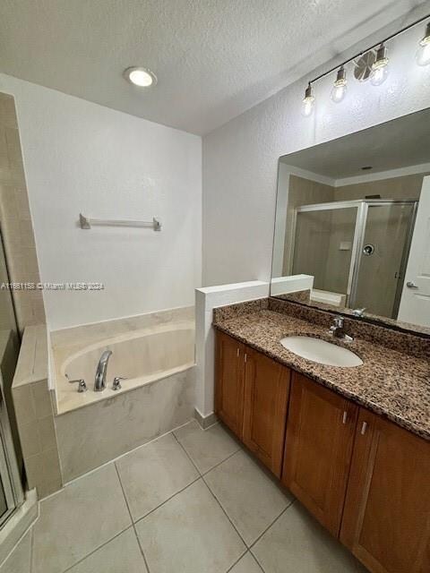 bathroom with tile patterned floors, a textured ceiling, vanity, and separate shower and tub