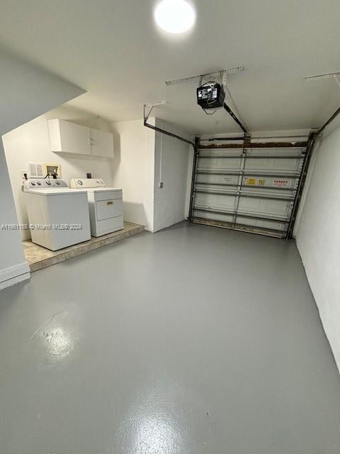 garage with a garage door opener and washer and dryer