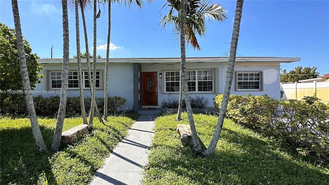 ranch-style home featuring a front lawn