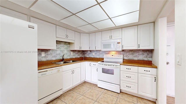 kitchen with sink, white appliances, white cabinetry, and light tile patterned floors