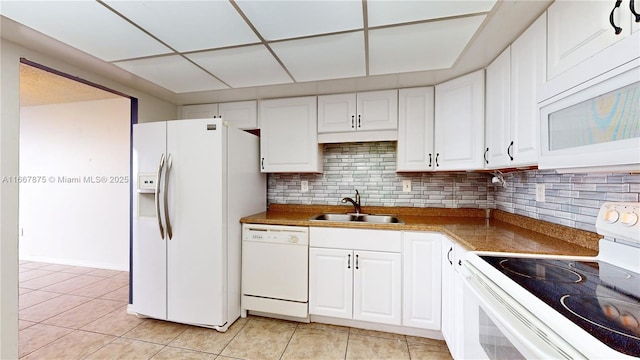 kitchen featuring white appliances, white cabinets, tasteful backsplash, sink, and light tile patterned floors