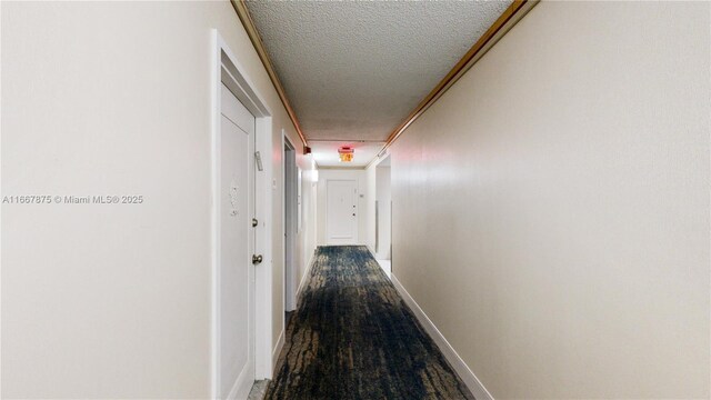 hallway featuring a textured ceiling, ornamental molding, and hardwood / wood-style floors