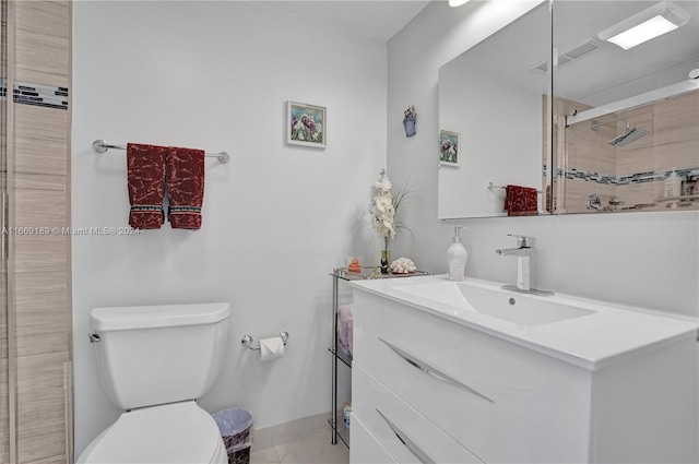 bathroom featuring a shower with door, vanity, and toilet