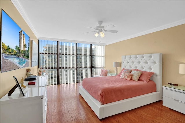 bedroom with ornamental molding, wood-type flooring, ceiling fan, and access to exterior