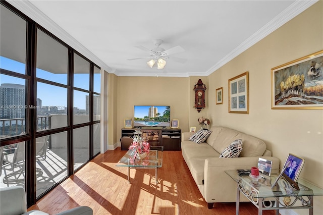 living room with wood-type flooring, ceiling fan, a wall of windows, and crown molding