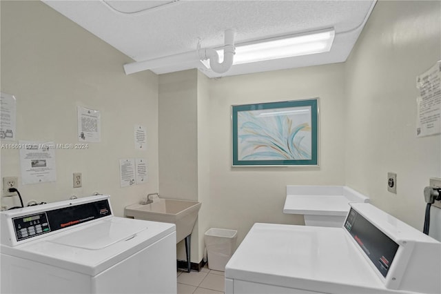 washroom featuring washer and clothes dryer, a textured ceiling, and light tile patterned floors