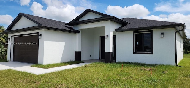 view of front of house with a front yard and a garage