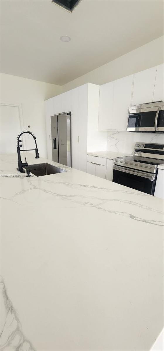 kitchen with white cabinets, stainless steel appliances, and sink