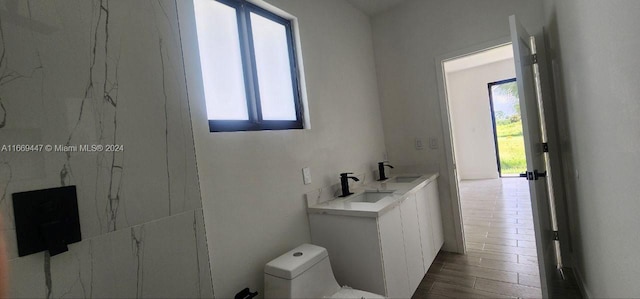 bathroom featuring walk in shower, vanity, toilet, and hardwood / wood-style flooring