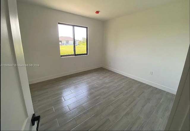 unfurnished room with dark hardwood / wood-style flooring