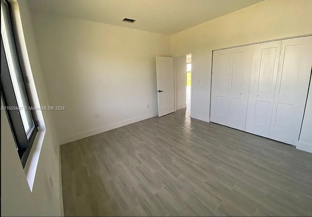 unfurnished bedroom featuring wood-type flooring and a closet