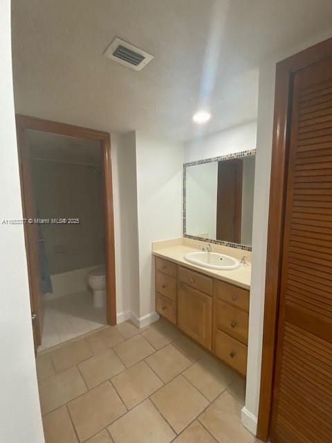 bathroom with tile patterned flooring, vanity, and toilet