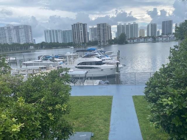 view of dock with a lawn and a water view