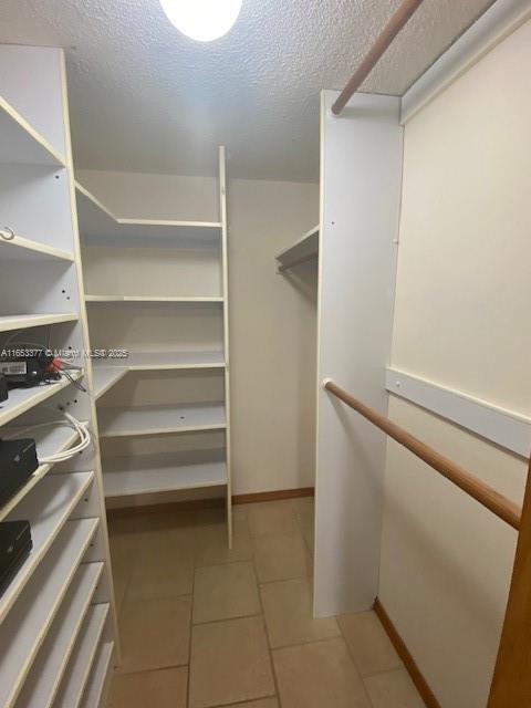 spacious closet with light tile patterned floors