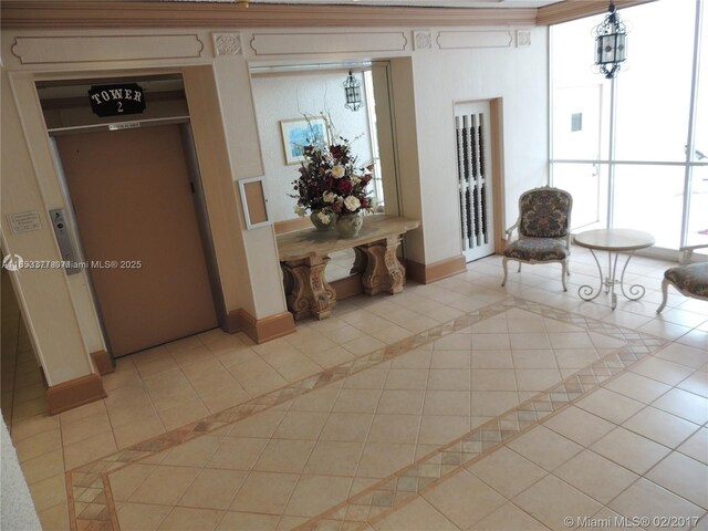 hall with light tile patterned floors, ornamental molding, and a mail area