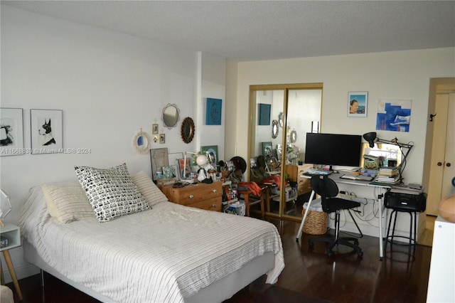 bedroom with a textured ceiling and dark hardwood / wood-style floors