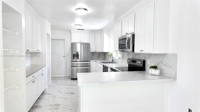 kitchen featuring sink, kitchen peninsula, white cabinets, and appliances with stainless steel finishes