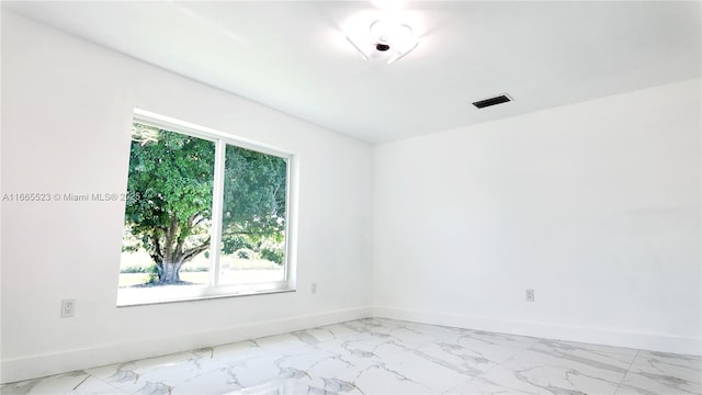 kitchen featuring plenty of natural light, stainless steel fridge, and white cabinetry