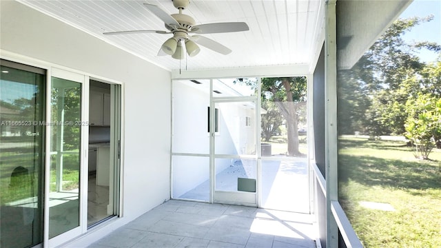 unfurnished sunroom with ceiling fan