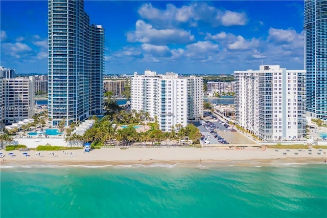 birds eye view of property with a water view and a beach view