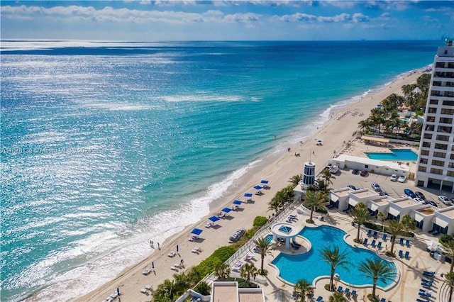 birds eye view of property featuring a beach view and a water view