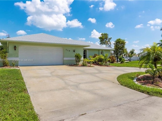 view of front of property featuring a front yard and a garage