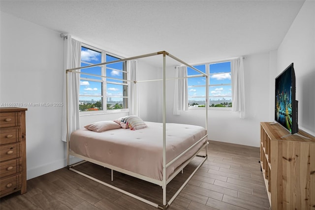 bedroom with dark hardwood / wood-style flooring and a textured ceiling