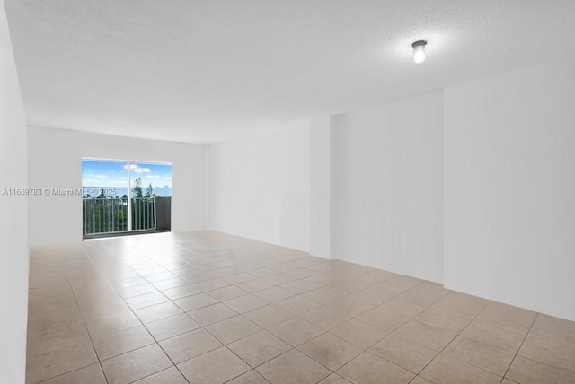 tiled empty room with a textured ceiling