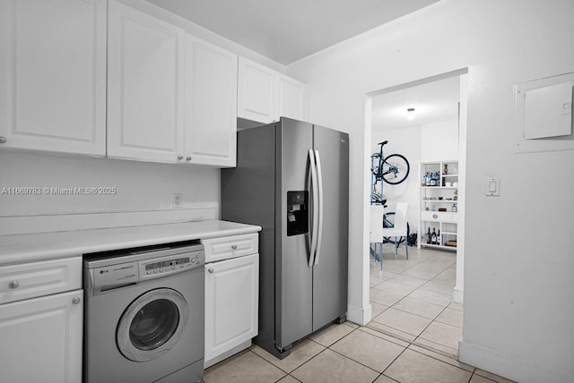 kitchen featuring washer / dryer, light countertops, white cabinets, and stainless steel refrigerator with ice dispenser